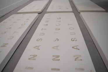 Sara Osman, Stuck Somewhere that I do not belong, 2020. Text embedded into Plaster [Installation], 203 x 128 cm.